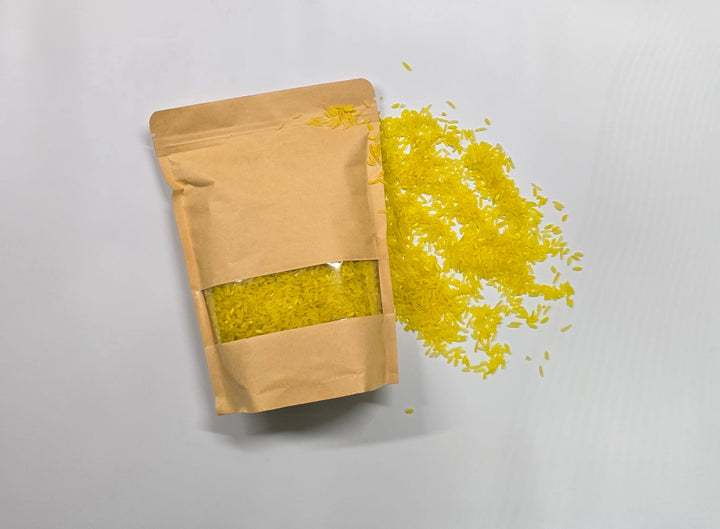 عبوة ألعاب حسية تعليمية من LITTLE ARTIST تحتوي على أرز أصفر ينساب للخارج للعب حسي.
